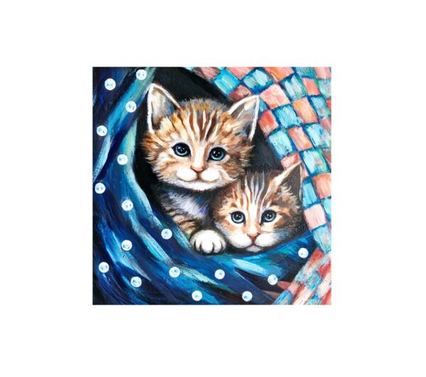 Magnet showing two ginger kittens peeking out from under a colorful, patterned blanket with polka dots.