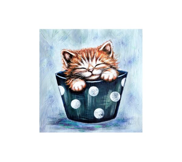 Magnet showing a ginger kitten with eyes closed, sleeping inside a dark cup with white polka dots.