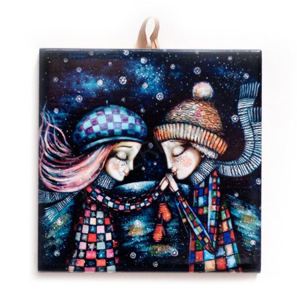 Ceramic tile artwork of a couple in colorful winter clothing and hats, holding hands tenderly under a snowy, starry night sky.